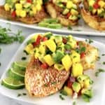 Broiled Red Snapper with Mango Salsa on top on white plate with more in background
