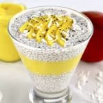 Mango Coconut Chia Pudding layered in glass with sliced mango and shredded coconut on top