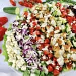 Greek Chicken Salad on white oval platter with creamy dressing drizzled on top