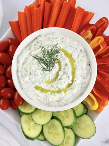 Tzatziki Sauce in white bowl with fresh veggies around