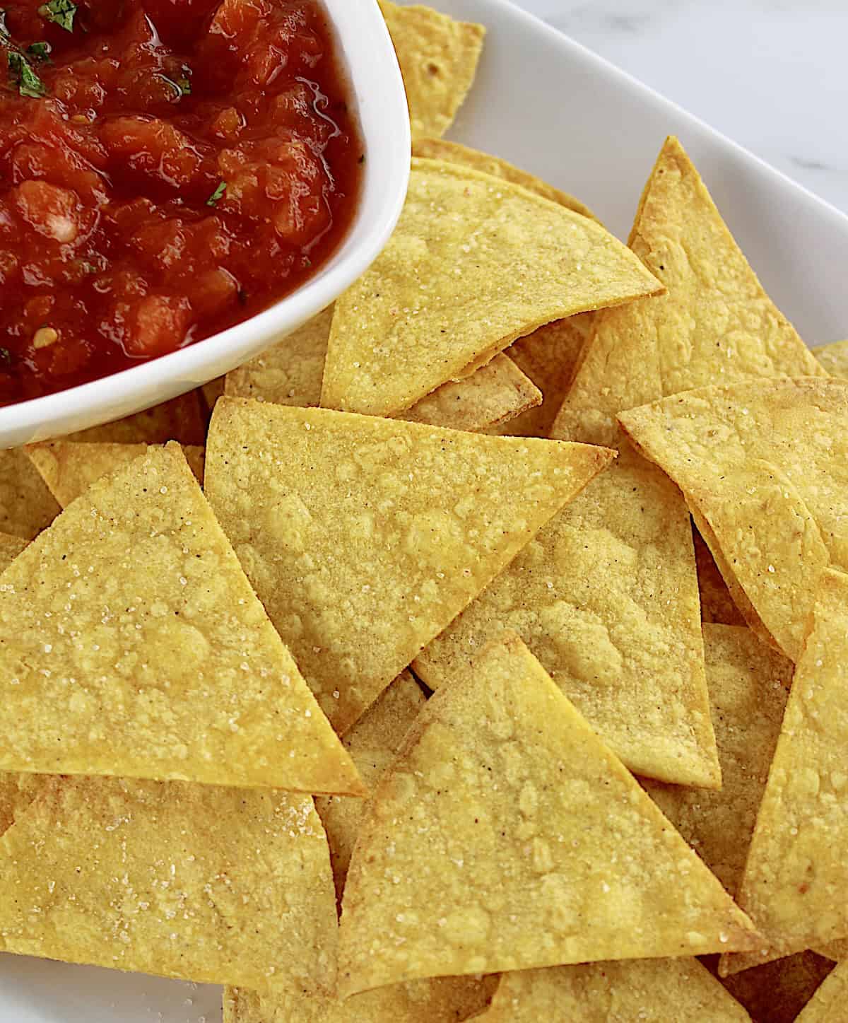 Easy Baked Tortilla Chips on white plate with salsa