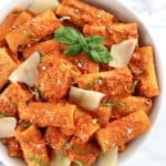 Roasted Pepper Pasta in white bowl with shaved parmesan and fresh basil on top