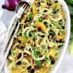 Shaved Fennel Salad on white oval plate with serving fork and spoon on side