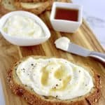 Whipped Ricotta Toast on cutting board with ricotta and honey in back