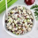 overhead view of Cranberry Pecan Chicken Salad in white bowl with silver serving spoon