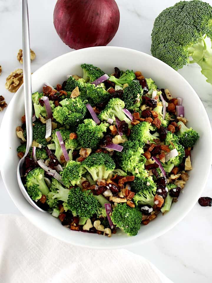 Broccoli Salad with Cranberries in white bowl with spoon