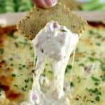 Chicken Cordon Bleu Dip being scooped out with cracker and cheese pulling