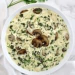 overhead view of Chicken Florentine Soup in white bowl with 3 mushrooms on top