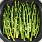 overhead view of Sautéed Asparagus in skillet with garlic butter on top