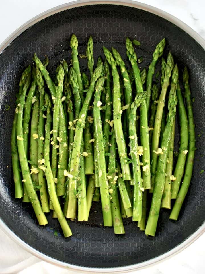 overhead view of Sautéed Asparagus in skillet with garlic butter on top