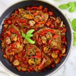 Steak Pizzaiola in skillet with fresh basil in center