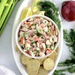 overhead view of Crab Salad in white bowl with crackers around