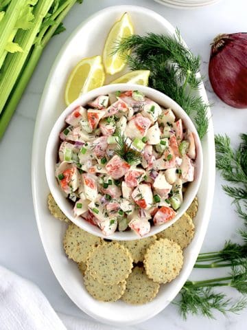 overhead view of Crab Salad in white bowl with crackers around