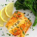 Easy Air Fryer Cod on white plate with broccoli and 3 lemon slices