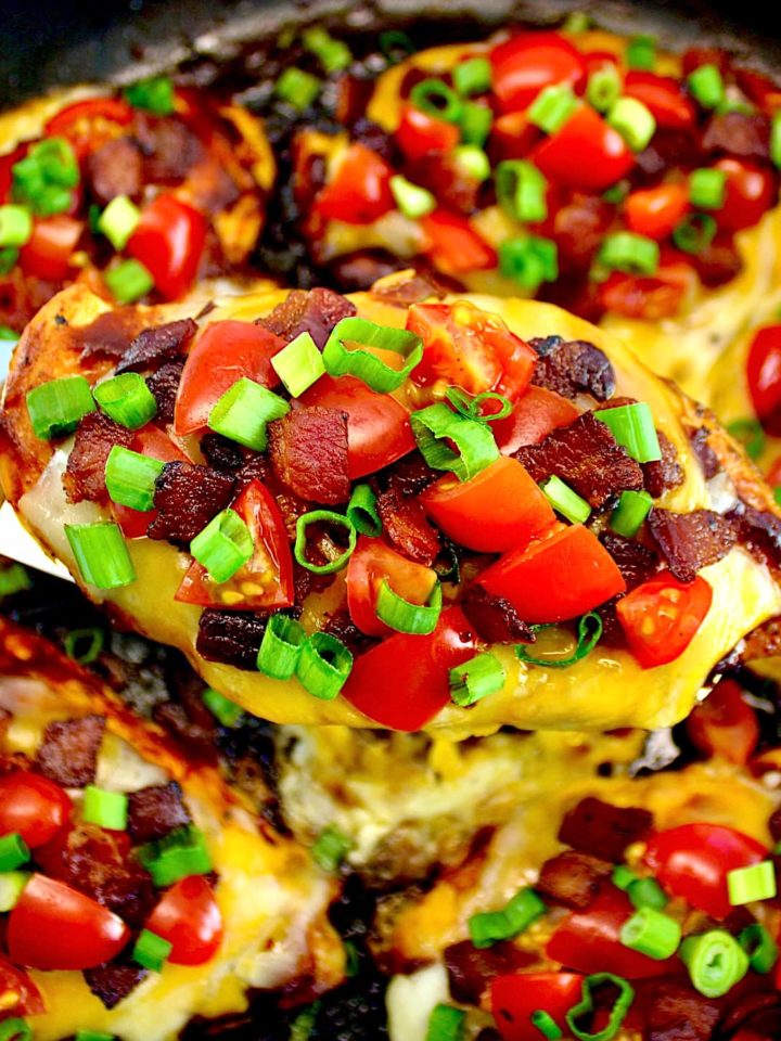 closeup of monterey chicken held up with spatula over skillet