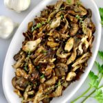 overhead view of Sautéed Wild Mushrooms on white oval platter