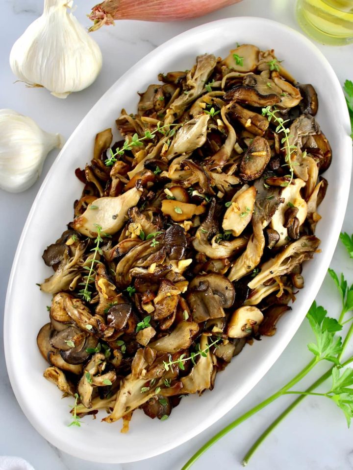 overhead view of Sautéed Wild Mushrooms on white oval platter