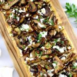 Wild Mushroom Pesto Flatbread on cutting board sliced into wedges