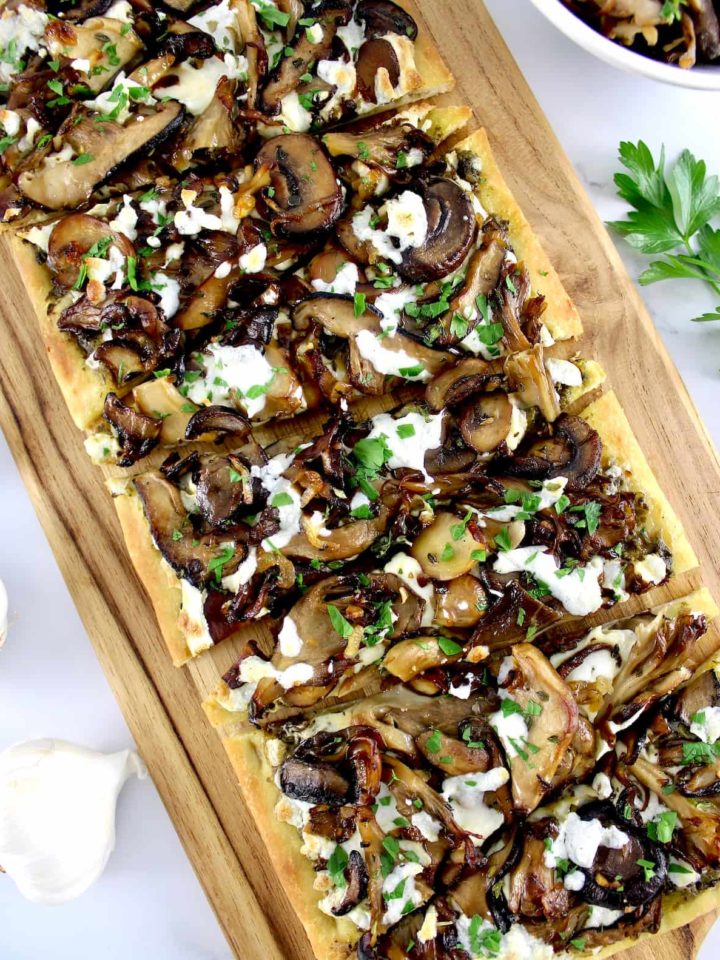 Wild Mushroom Pesto Flatbread on cutting board sliced into wedges